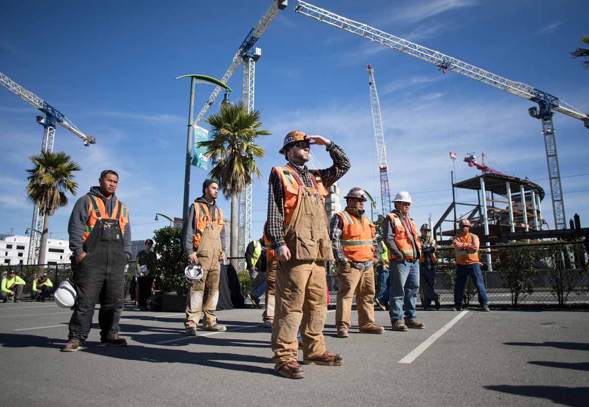 Construction staff at Mission Bay look up at their work.