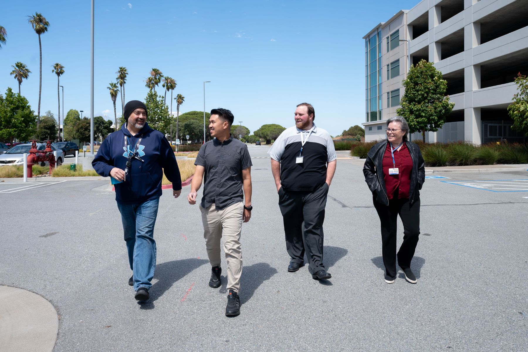 Four coworkers walking together in an outdoor courtyard.