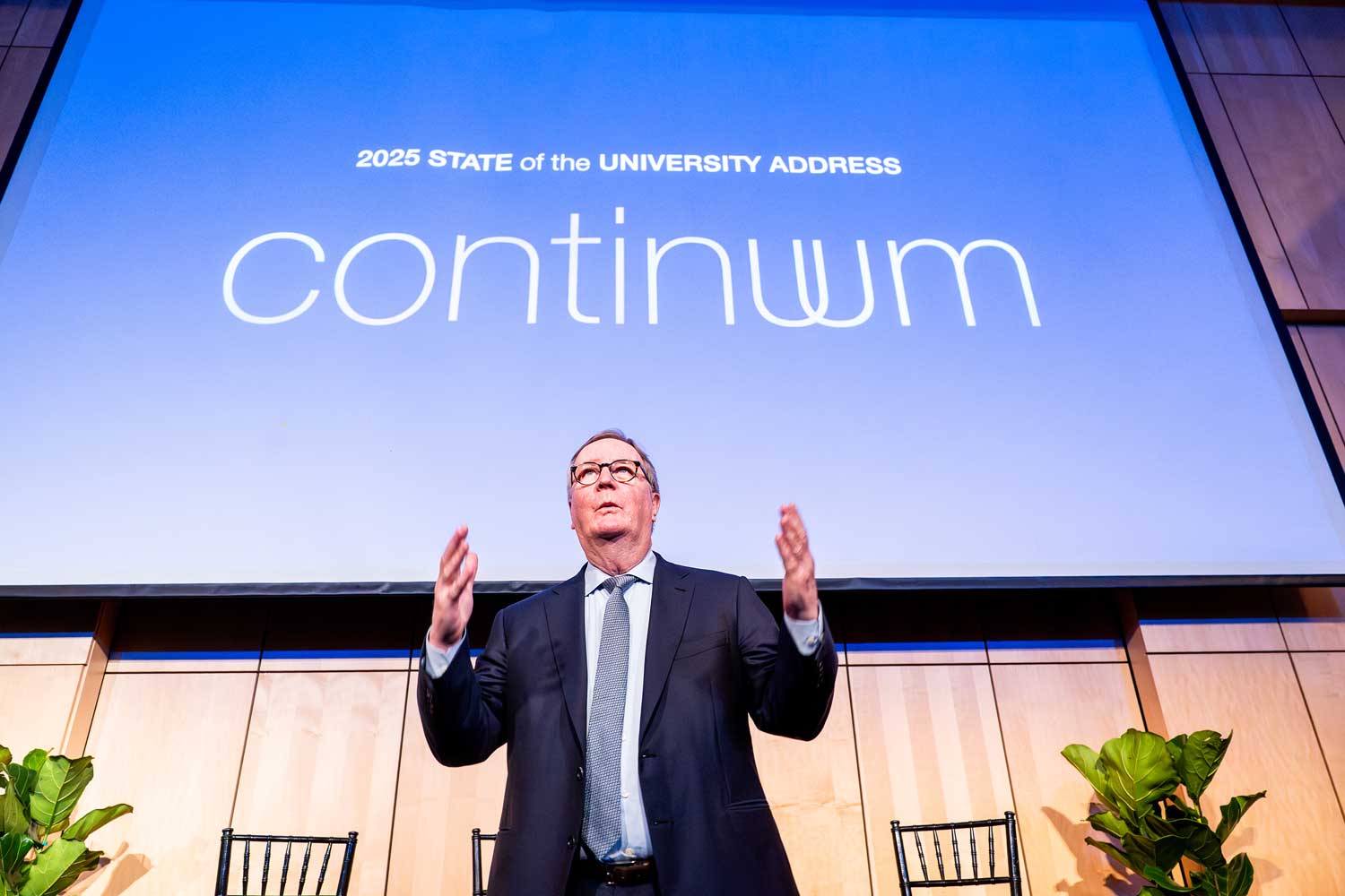 Chancellor Hawgood delivers his 2025 State of the University address. Behind him is a projection screen that has the title of the address, called "Continuum."