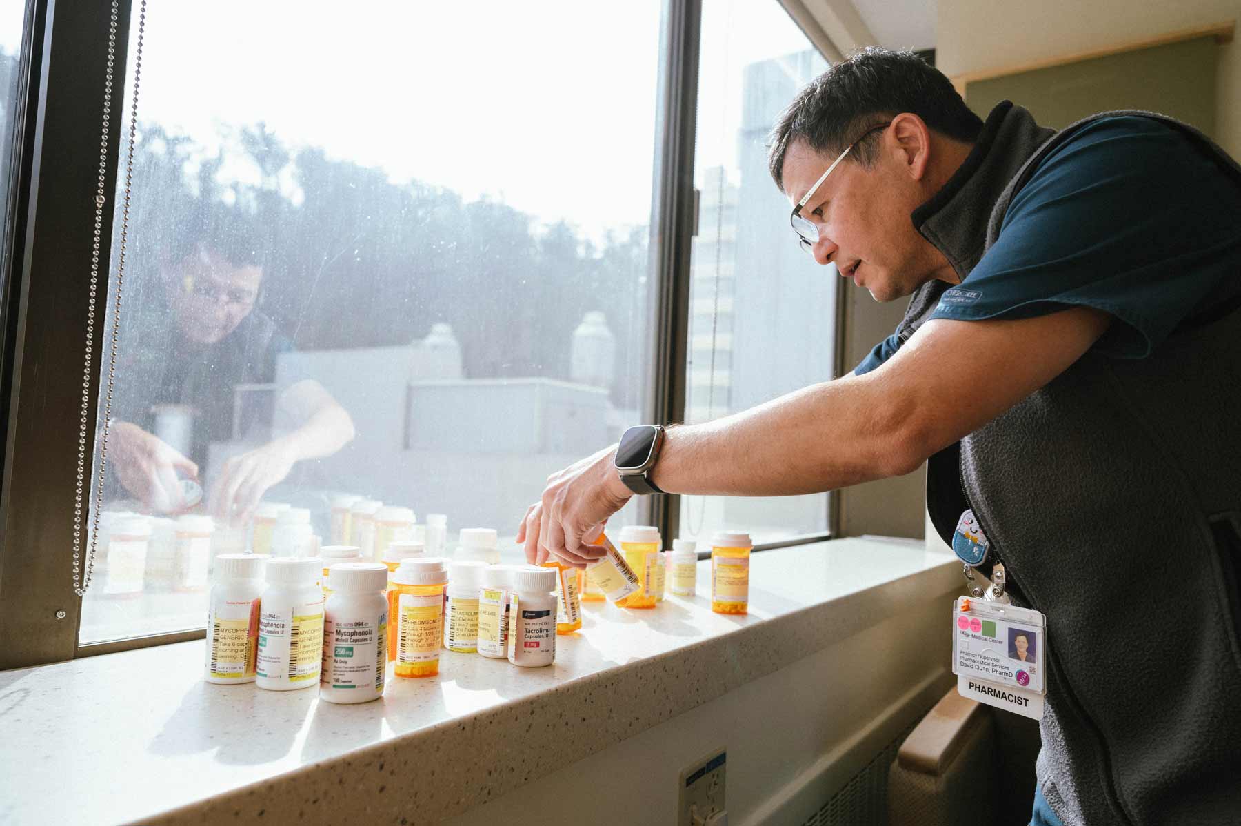 A pharmacist shows the many medications that kidney transplant patients need to take on a daily basis.