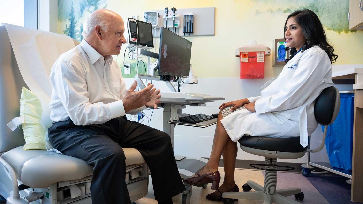 Dr. Aparajita Singh sits with her patient Bill in a well-lit examination room.