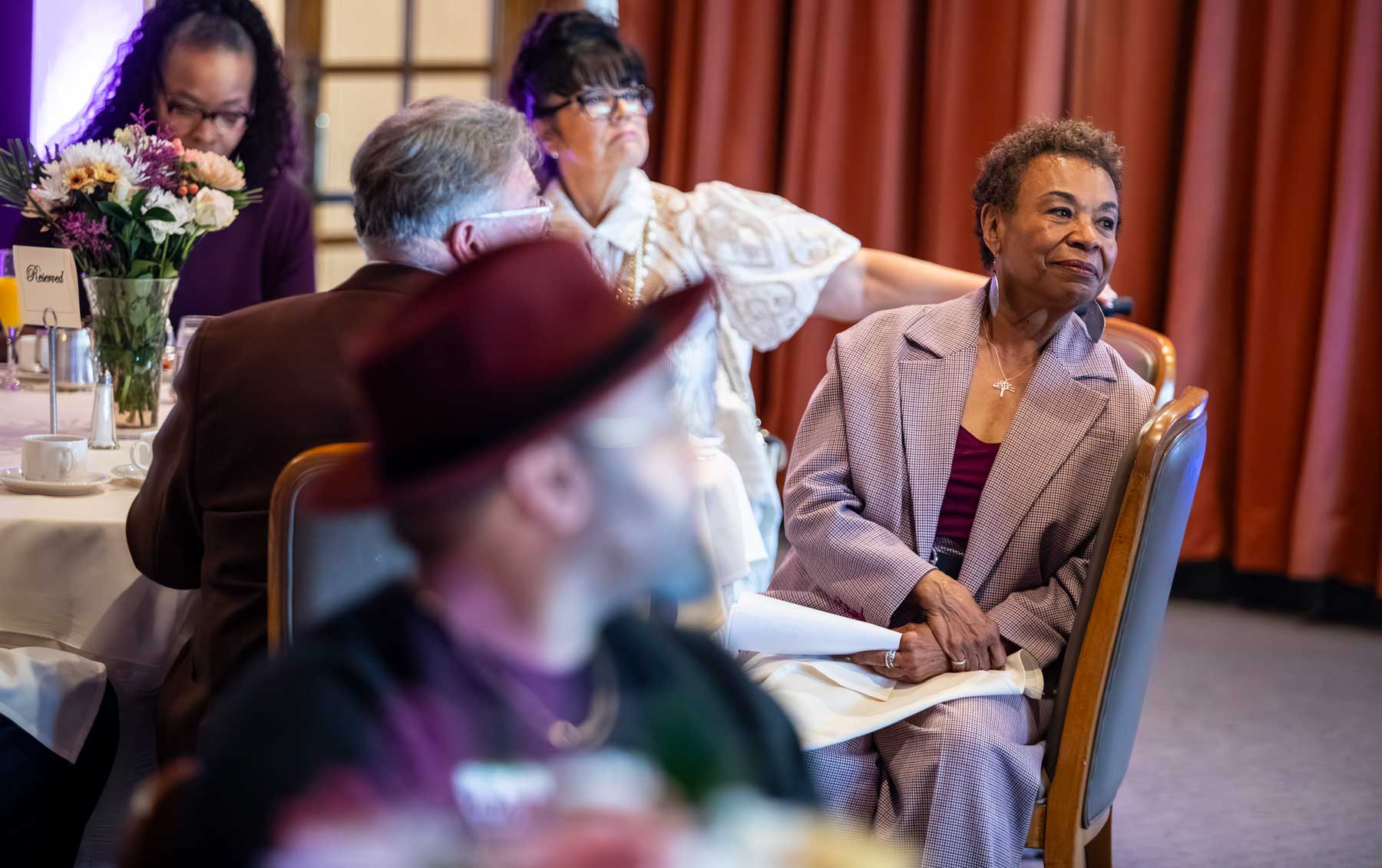 Oakland mayor Barbara Lee sits at a table with event attendees.