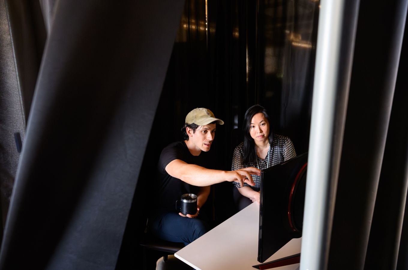 Researchers Adam Yala and Maggie Chung discuss while looking at a computer screen.