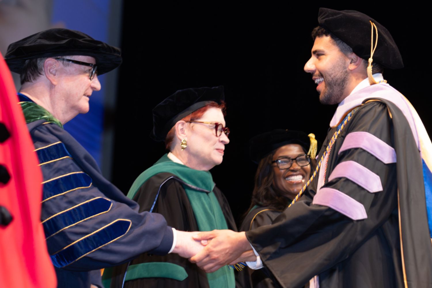 Chancellor shakes student's hand.