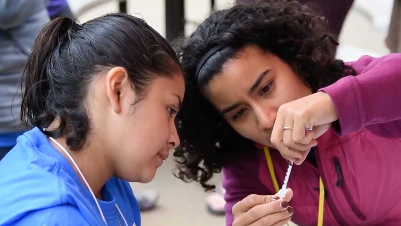 Celina Trujillo teaches a preteen girl how to measure glucose.