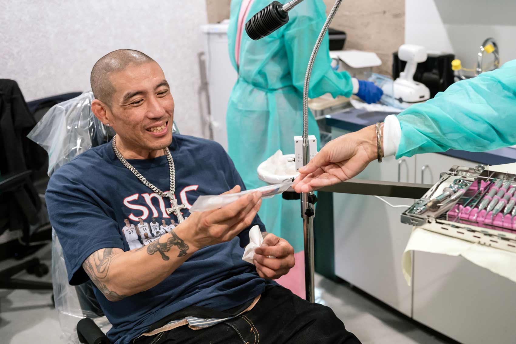 A patient at Citywide Dental smiles as receives a toothbrush from a dentist.