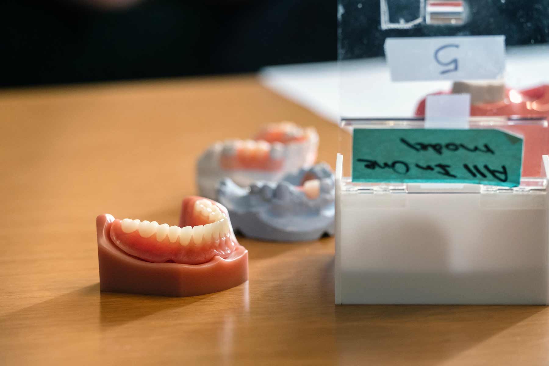 Different sized dentures sit on a table for demonstration.