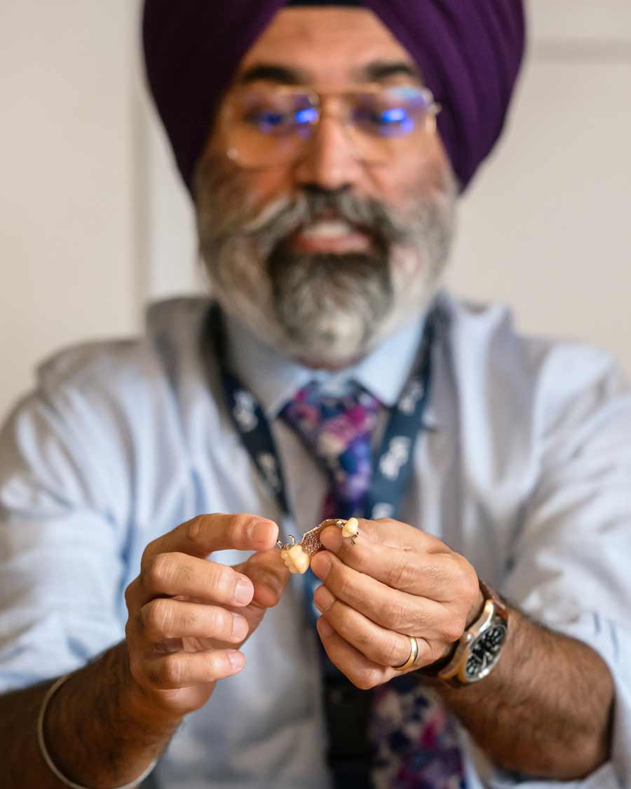 Gurrinder Atwal holds a dental implant.