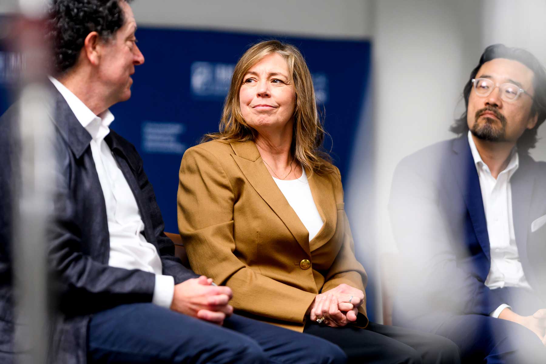 Cancer patient Terri Conneran sits with Kevan Shokat and other scientists on a stage.