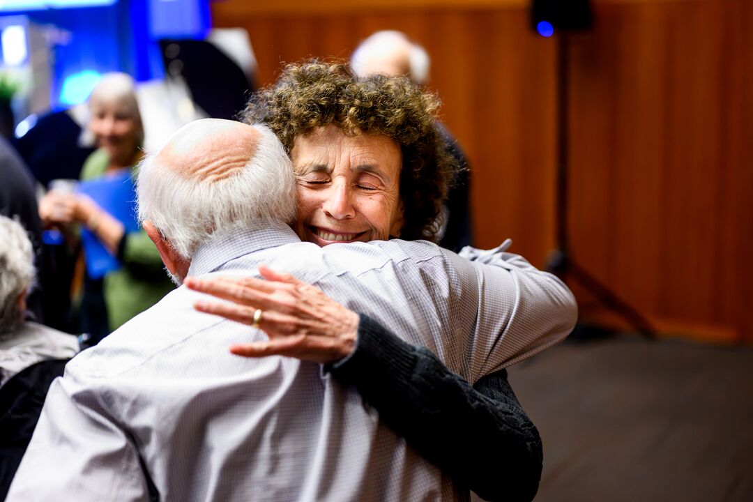Two attendees share a hug at J. Michael Bishop's memorial.