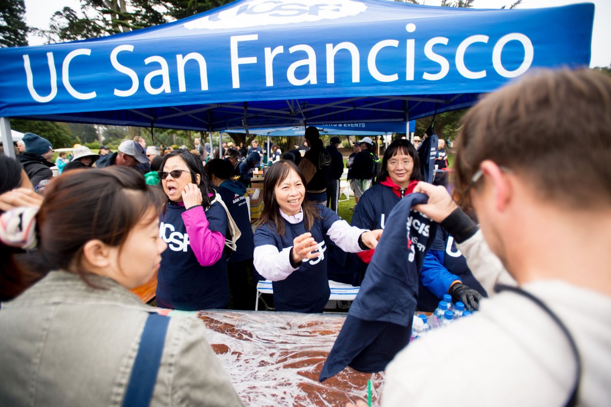 Volunteers hand out UCSF t-shirts to registered walkers.
