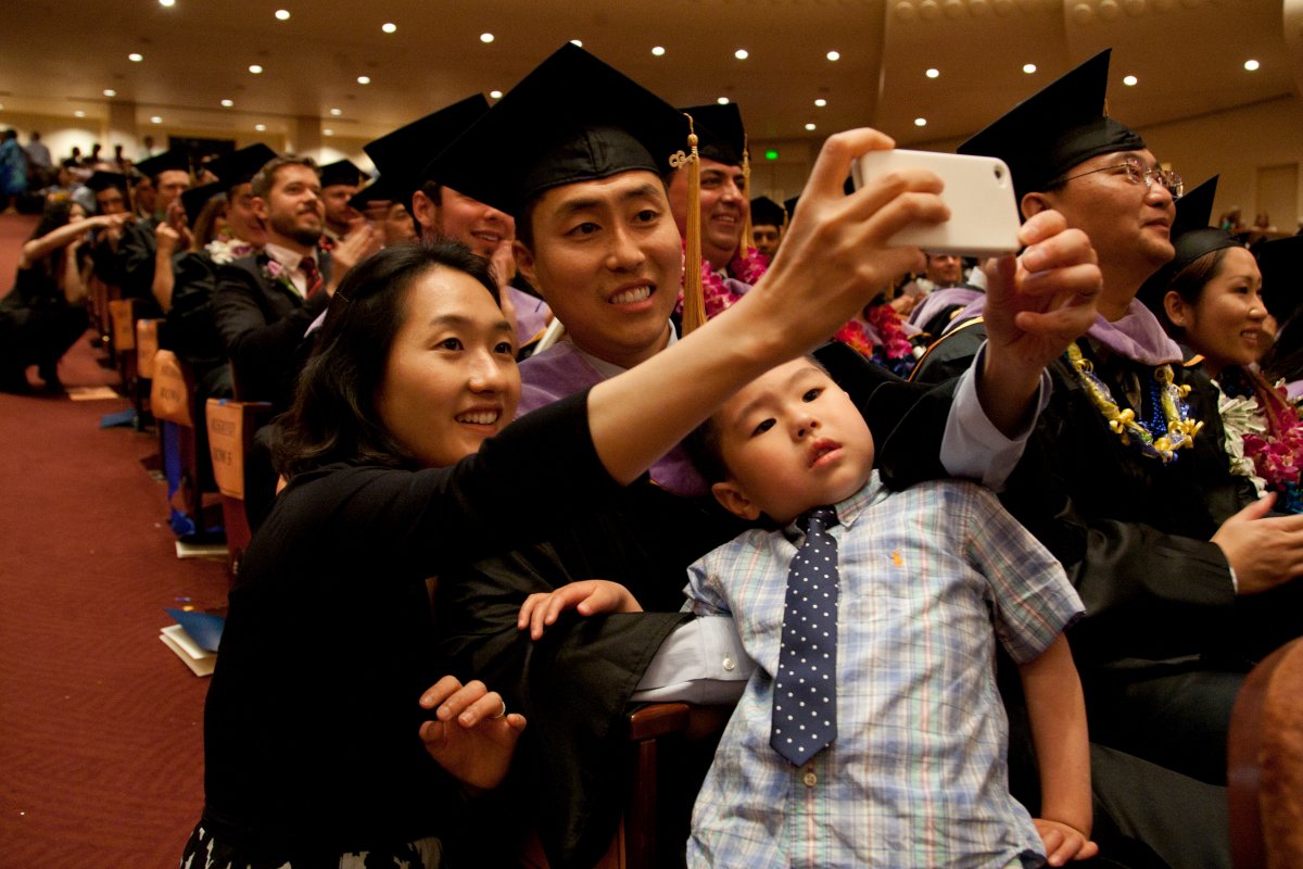 Dental school graduate Kwang Chang takes a family photo with his wife Myung Hee Song and son, Ethan, 4, during the commencement ceremony.