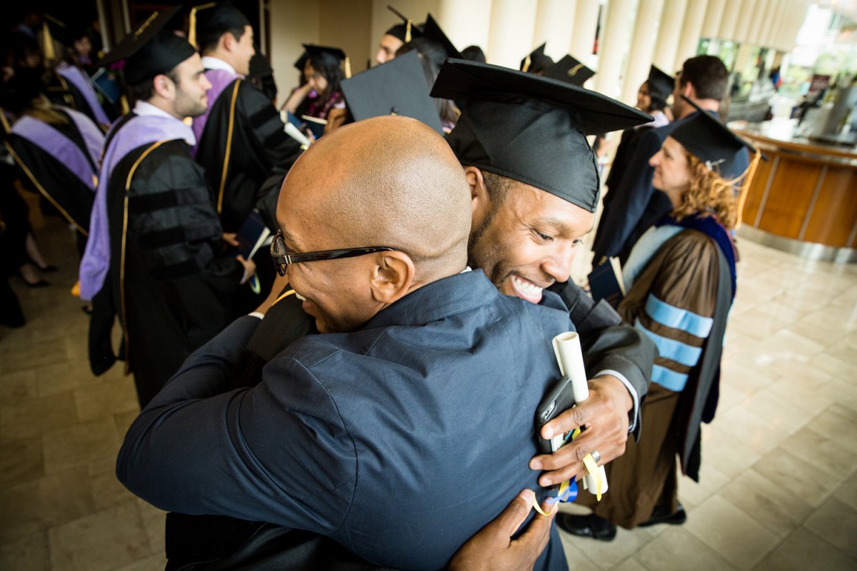 School of Dentistry graduate Eric Brown receives a hug after the commencement ceremony.