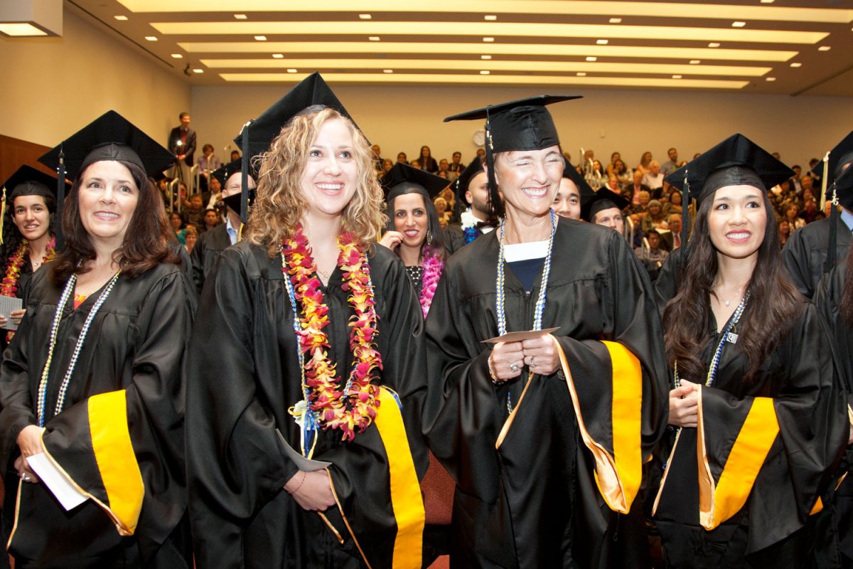 Graduate Division students stand in preparation for being called to the stage to be hooded during their commencement ceremony in Robertson Auditorium at Mission Bay.