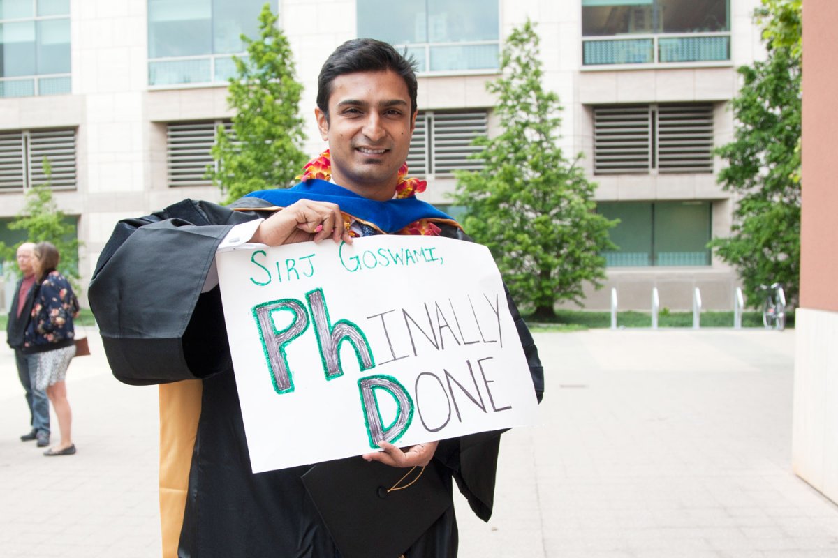 Srijib Goswami, a Discovery Fellow in the Department of Pharmaceutical Sciences and Pharmacogenomics, poses with a sign "Phinally Done" (letters Ph and D are emphesized).