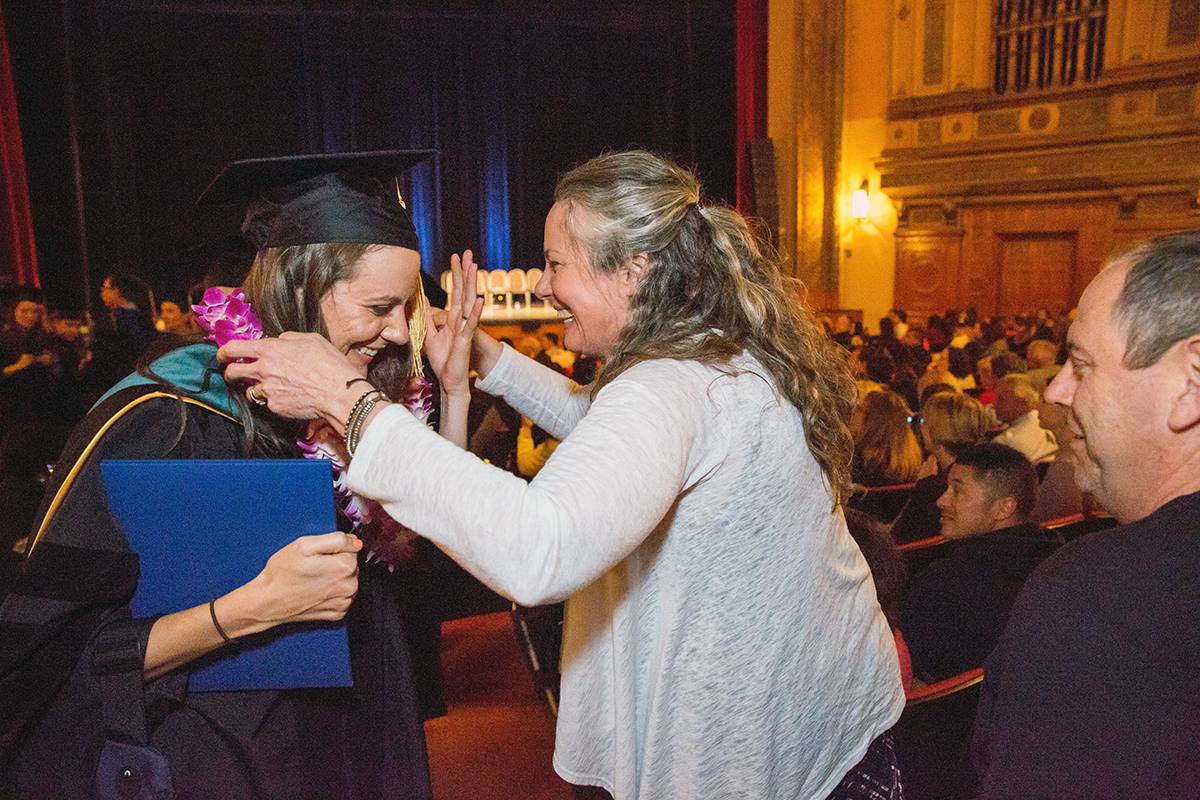Laura McIlvoy receives a lei from her mother after receiving her Doctorate in Physical Therapy degree at the Graduate Division commencement ceremony in the Nourse Theater in San Francisco.