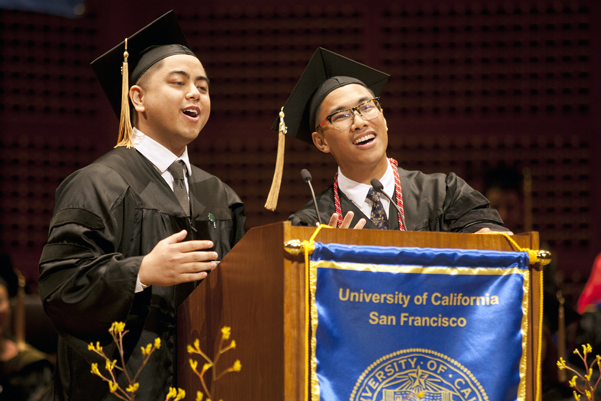 School of Pharmacy graduates Michael De Guia (left) and Ronnie Delmonte (right) sing during the school's commencement ceremony.