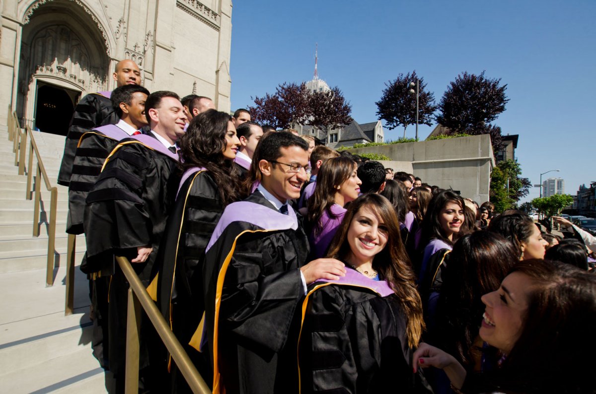 Dalia Al-Qaraghuli, graduating from the International Dentist Program, flashes a smile at the camera as she and her fellow School of Dentistry students gather on the steps of Grace Cathedral before their June 11 commencement ceremony.