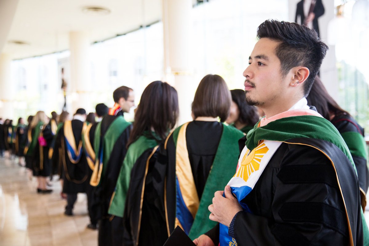 Ruben Lachica lines up with his classmates in the lobby of Davies Symphony Hall before the School of Medicine commencement ceremony.