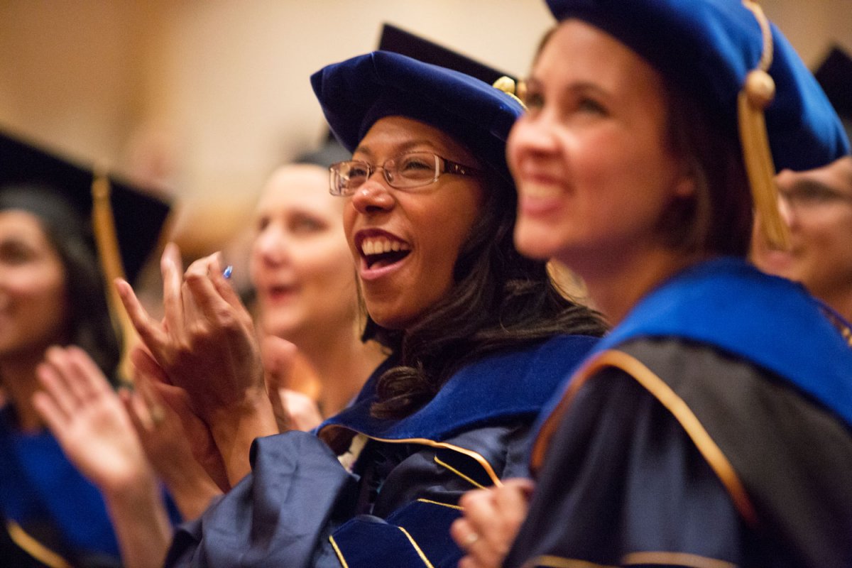 Holly Jones (center) and Quinn Grundy (right) have a laugh during the School of Nursing commencement ceremony.