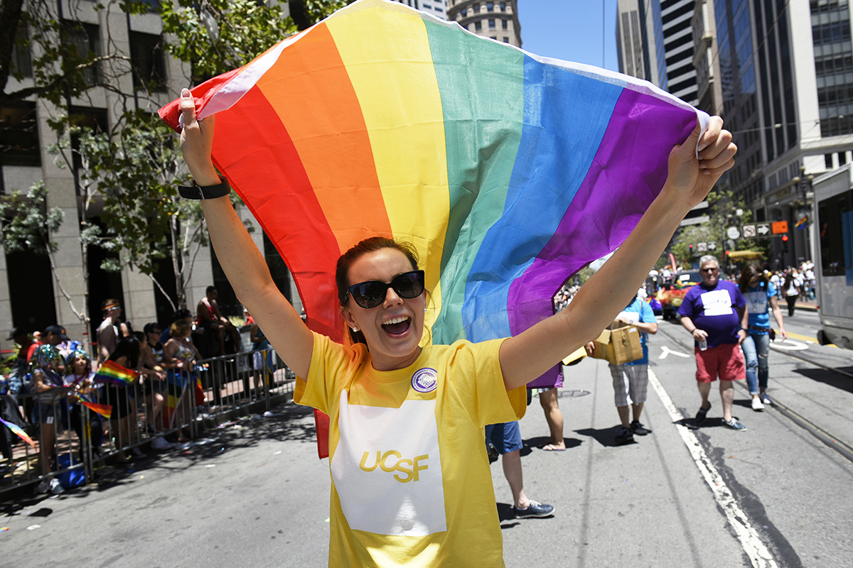 A member of UC San Francisco's Pride Parade contingent carries a rainbow flag during the Sunday event.