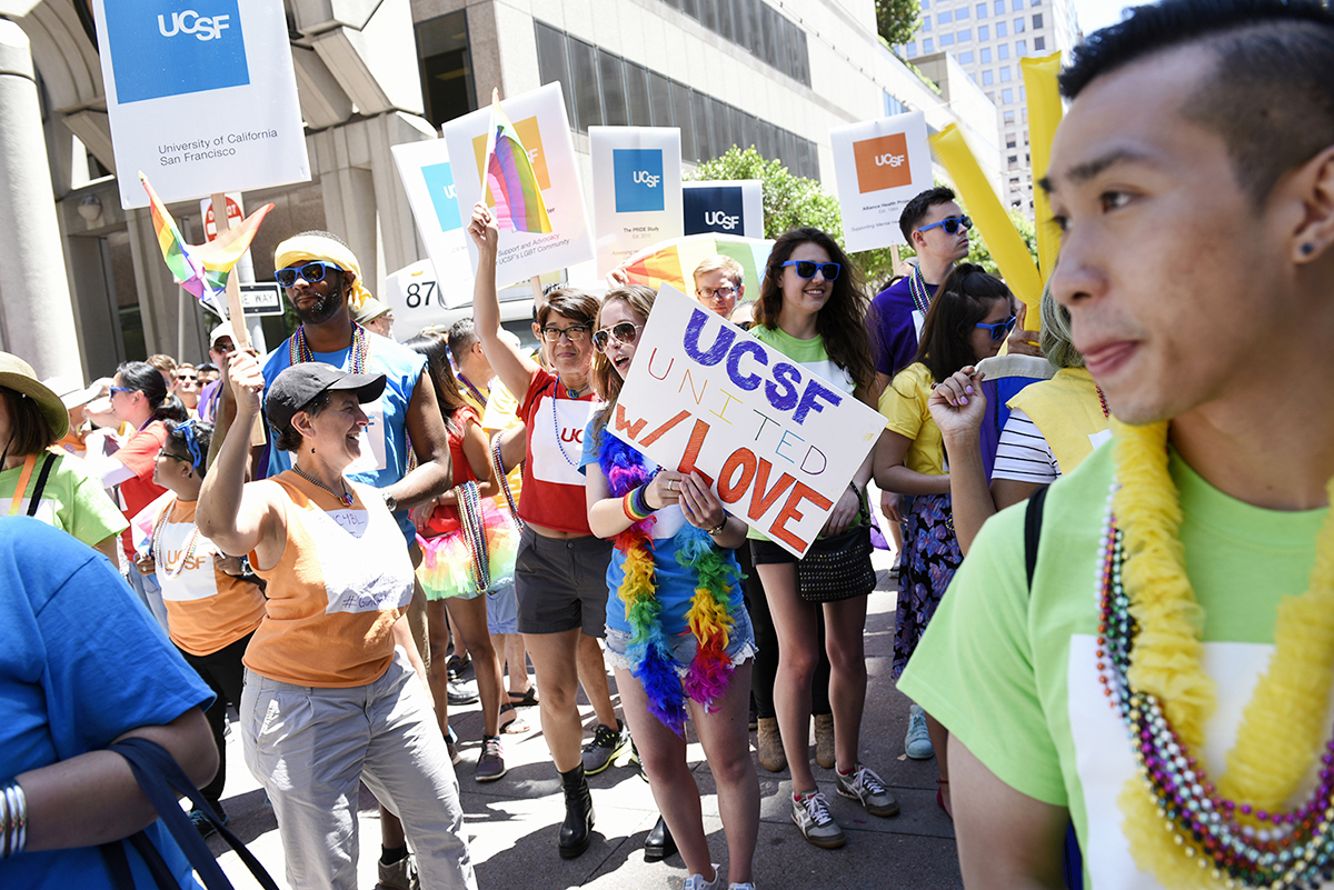 A member of UC San Francisco's contingent in the San Francisco Pride Parade holds a "UCSF United w/ Love" sign during the parade.