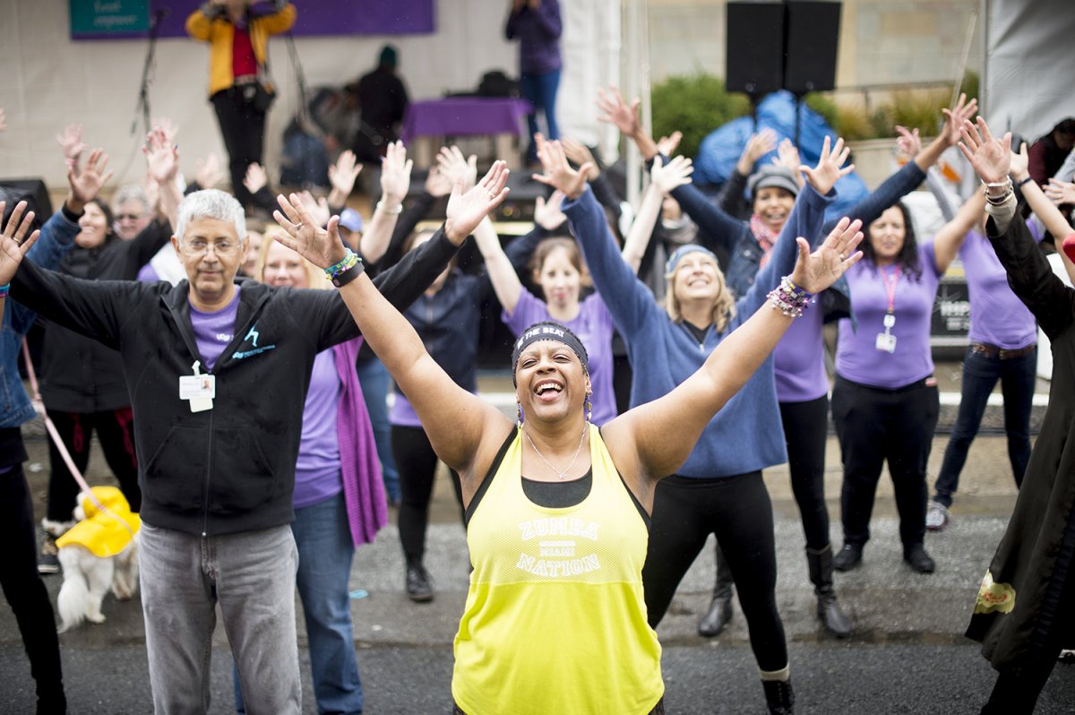 Judy Young, MPH, the assistant director of the UCSF National Center of Excellence in Women’s Health, leads a flash mob dancing in support of domestic violence victims during the center's 20th anniversary celebration. 
