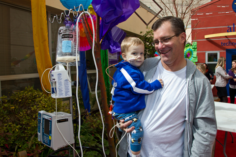 UCSF patient, 8-month-old Riggs Grassinger enjoys the Art Day festivities with his father, Mark Grassinger.
