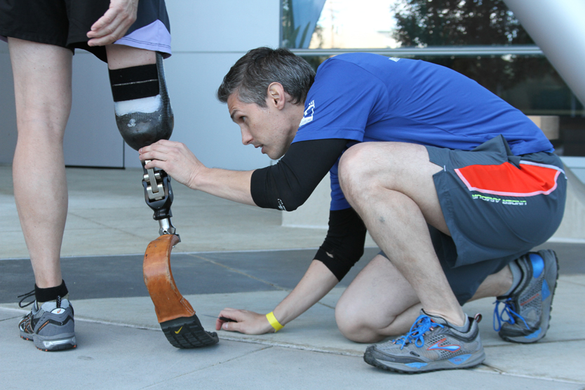 Matthew Garibaldi, CPO, director of the Orthotics & Prosthetics Centers at UCSF, fine-tunes amputee athlete Geoff Turner's running blade.