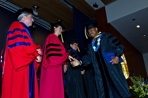 Graduate Division Dean Elizabeth Watkins congratulates a graduate while Jeffrey Bluestone, executive vice chancellor and provost, looks on.