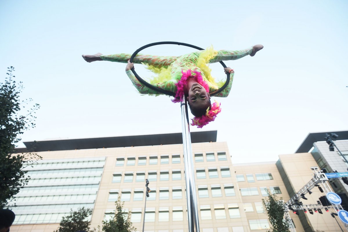 An acrobat hovers over the crowd during the Lights On Festival outside the new medical center complex.