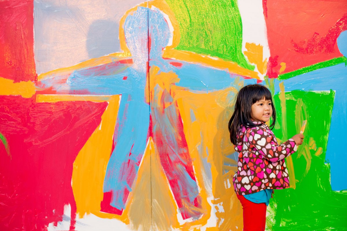 Gjelina Abrenico, 3, helps paint a mural during the Lights On Festival.