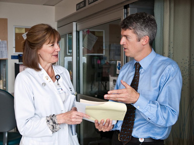 Neurologist S. Claiborne “Clay” Johnston, MD, PhD, speaks to a colleague at UCSF