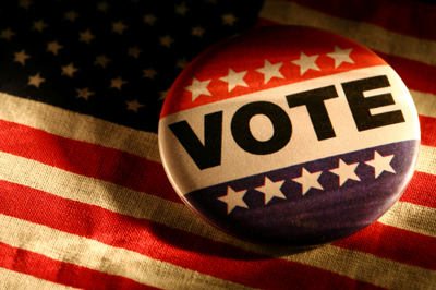 Stock image of Vote Pin button on an American flag