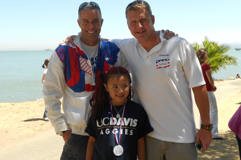 Former Olympic swimmers Dan Veatch, left, and Mark Henderson, right, pose with budding swimmer, Miya French, who received a liver transplant.