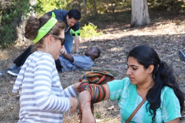 A HEAL Initiative fellow wraps the arm of a volunteer pretending to be injured during a training exercise