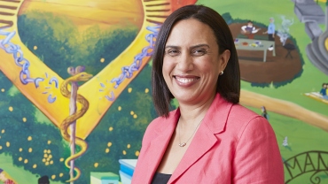 Dr. Bibbins-Domingo in front of a colorful mural