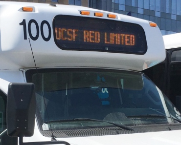 A UCSF shuttle with the a sign that reads "UCSF Red Limited"
