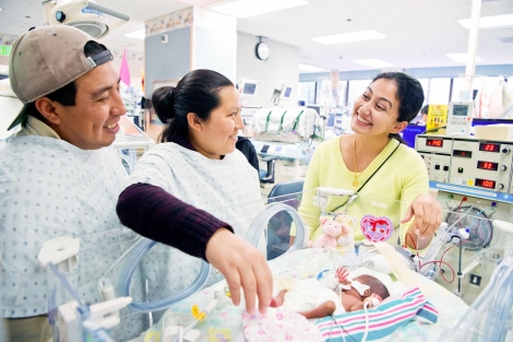 parents with their premature baby talk with a neonatologist in the hospital