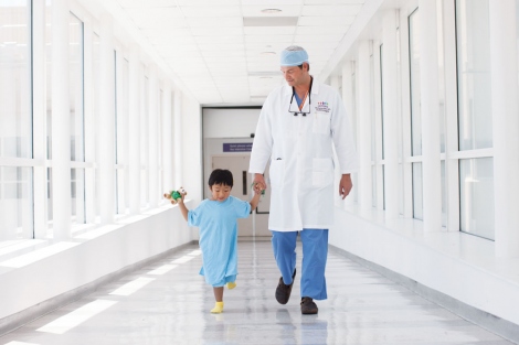 Dr. Wolfgang Stehr walking a young patient down the hall