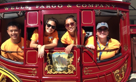 The Campus Life Services (CLS) team, organizers of the annual Block Party — from left, Andrew Lok, Tamara Villarina, Tiffany Tsan and Jennifer Dowd — sit inside a replica of a 19th Century Wells Fargo stagecoach