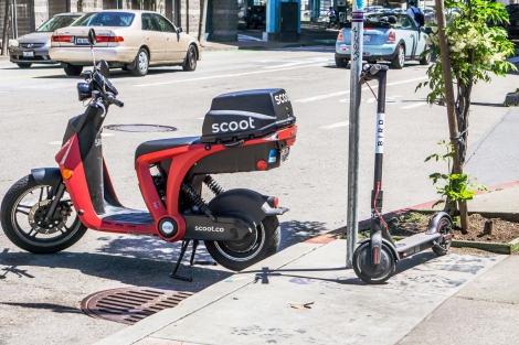Motor scooter and kick scooter on the street