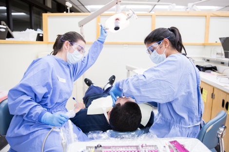 Tanya Varimezova and Yuvika Raj Kumar work on a patient in the UCSF Dental Center