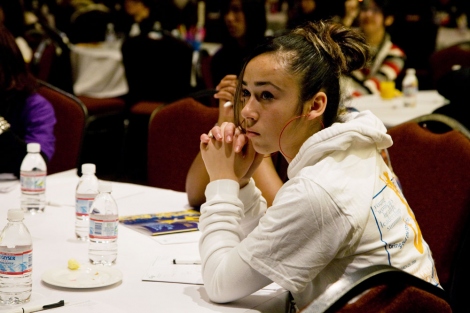 a teen girl listens to speakers at a Young Women's Health Leadership Summit event