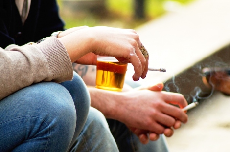 people smoke cigarettes while holding beer