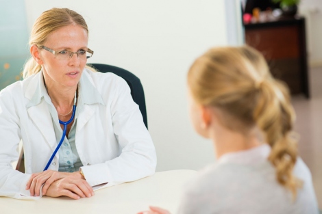 stock image of doctor talking to a teen patient