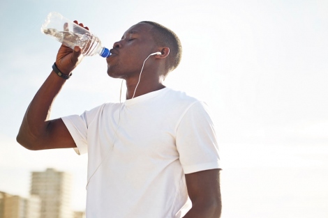 man drinking from a bottle of water during a workout