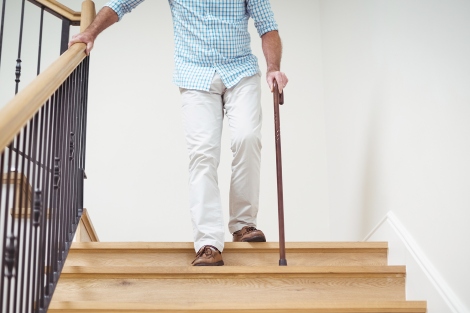 man walking down stairs with a cane