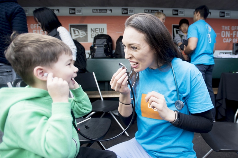 Misty Montoya teaches a child about stethoscopes at one of UCSF’s hands-on learning exhibits during 2017's Bay Area Science Festival Discovery Day