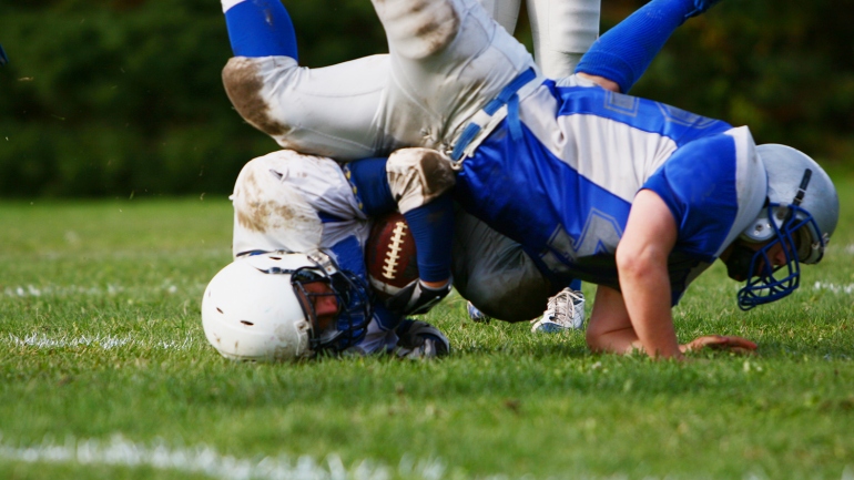 Football player getting tackled. 